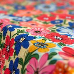 Macro di una trama di tessuto in cotone con una delicata stampa floreale, colori vivaci.